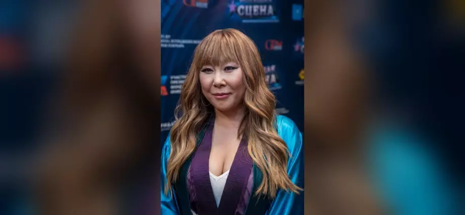 Анита Цой с длинными волосами на фоне баннера конкурса «Большая сцена»