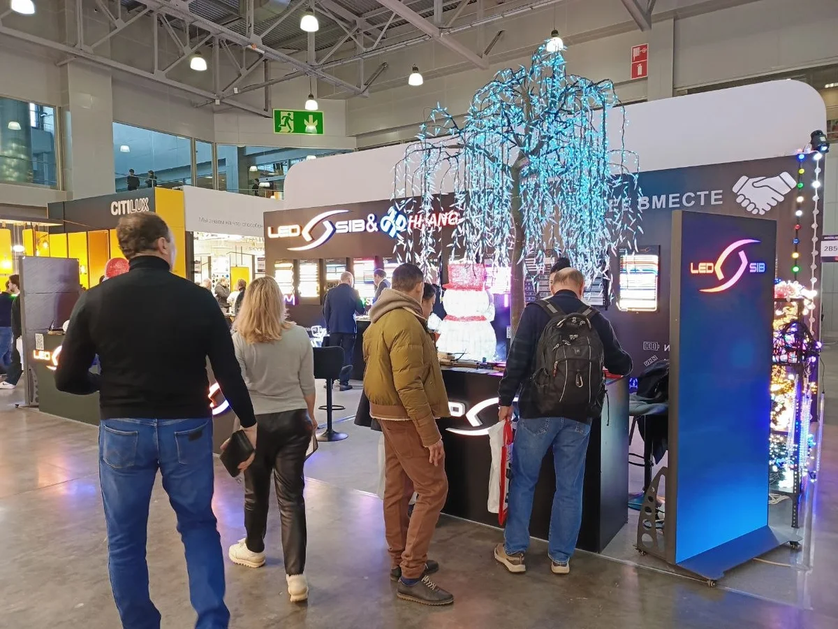 Большое светящееся дерево на стенде LED-SIB, посетители у стойки