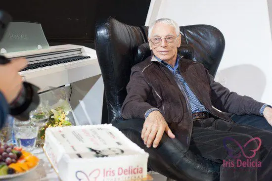 Композитор Александр Зацепин в кресле, рядом торт Iris Delicia