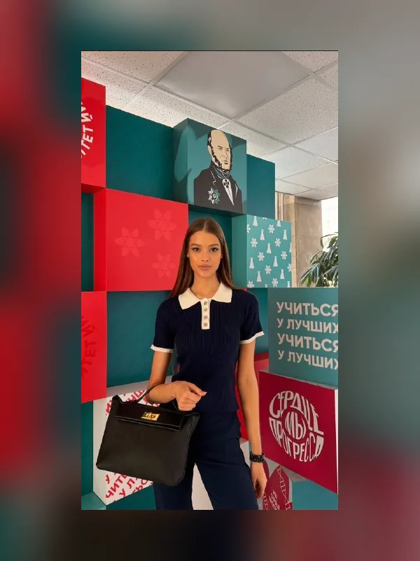 Валентина Алексеева в тёмно-синем поло на фоне ярких стендов