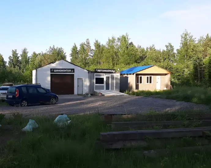 Иллюстрация: здание шиномонтажа и автомойки, рядом припаркованы машины